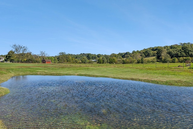 view of water feature with fence and a rural view