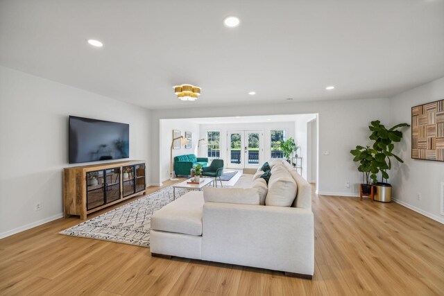 living area with recessed lighting, french doors, baseboards, and light wood finished floors