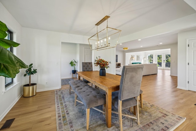 dining room featuring baseboards, visible vents, french doors, light wood-type flooring, and recessed lighting