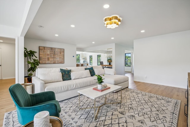 living room featuring light wood finished floors, baseboards, and recessed lighting