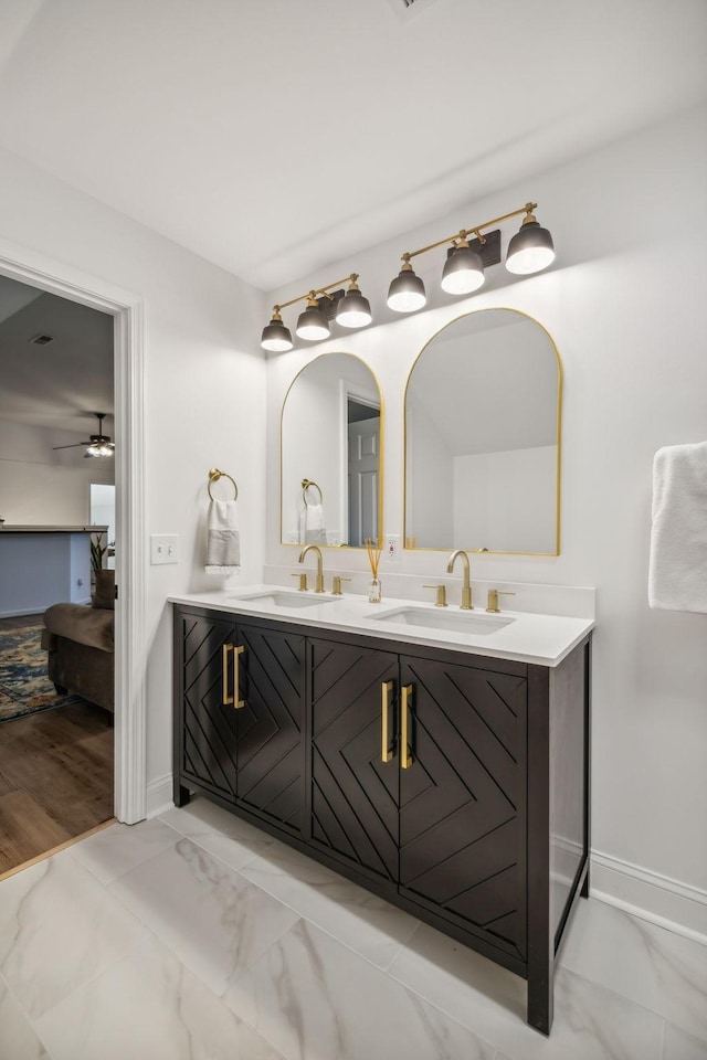 ensuite bathroom featuring marble finish floor, a sink, and double vanity