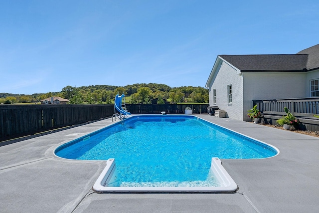 view of pool featuring a water slide, a patio area, a fenced backyard, and a fenced in pool