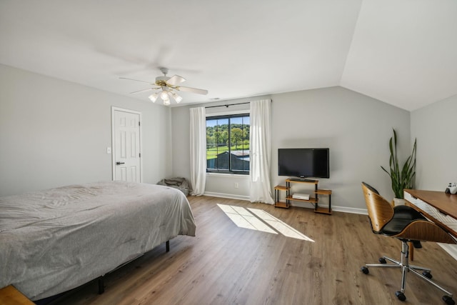 bedroom featuring lofted ceiling, ceiling fan, wood finished floors, and baseboards