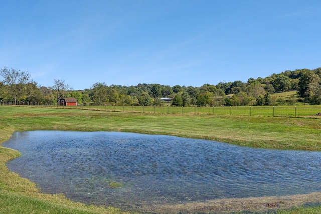 view of water feature with a rural view and fence