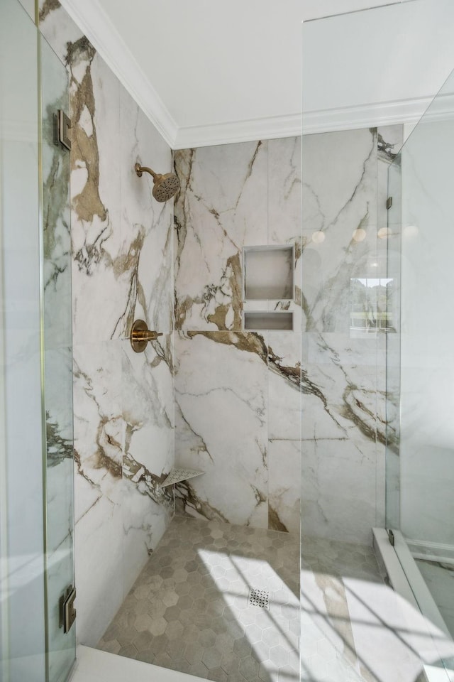 bathroom with a marble finish shower and ornamental molding