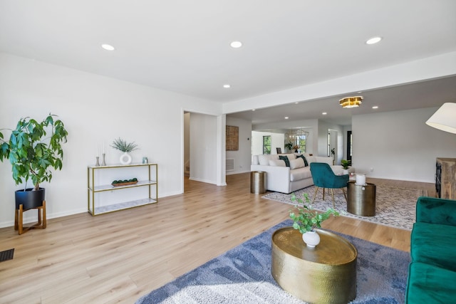 living room with light wood-type flooring, baseboards, visible vents, and recessed lighting