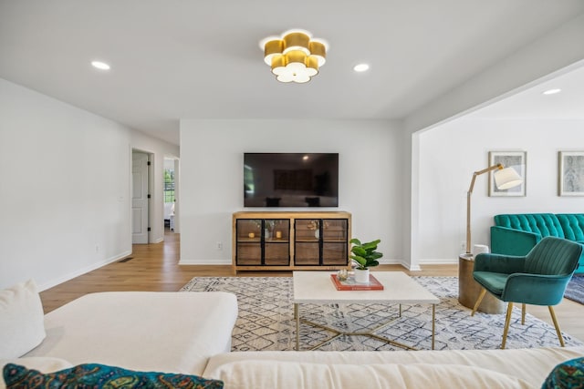 living room with recessed lighting, baseboards, and light wood finished floors