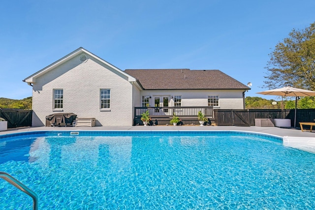 view of pool featuring a grill, a wooden deck, a fenced in pool, and fence