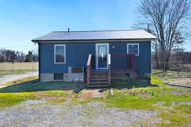 view of front of home featuring fence and metal roof