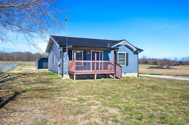 view of front of house with crawl space, covered porch, fence, an outdoor structure, and a front lawn