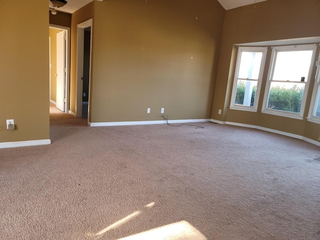 empty room featuring baseboards and light colored carpet