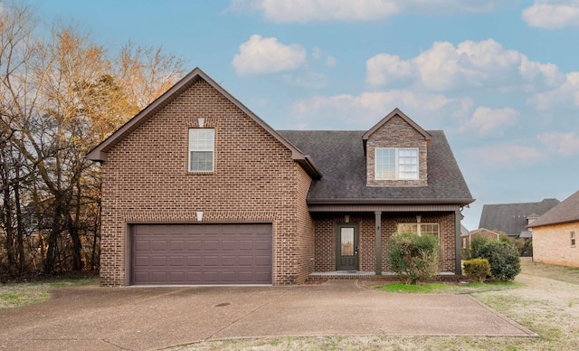 traditional-style home with an attached garage, roof with shingles, concrete driveway, and brick siding