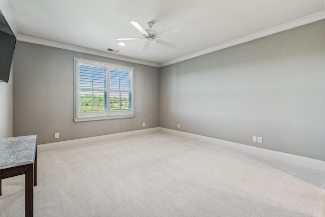 spare room with light carpet, baseboards, visible vents, and crown molding