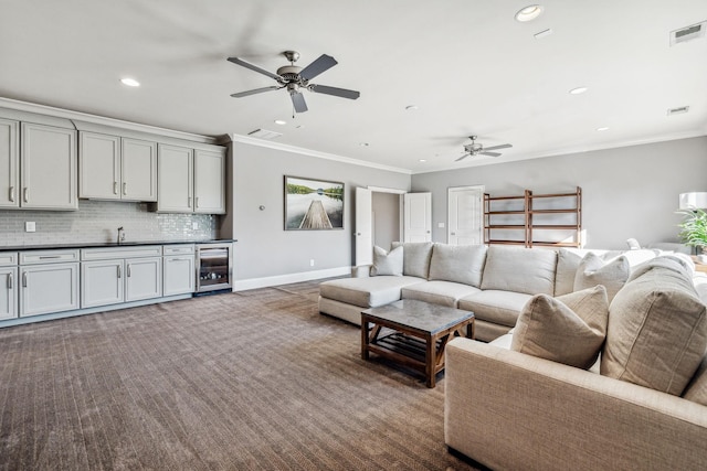 living room featuring beverage cooler, dark colored carpet, visible vents, and crown molding