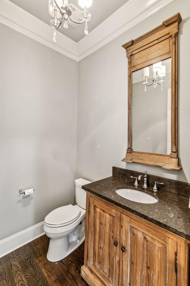 bathroom featuring toilet, an inviting chandelier, crown molding, and wood finished floors