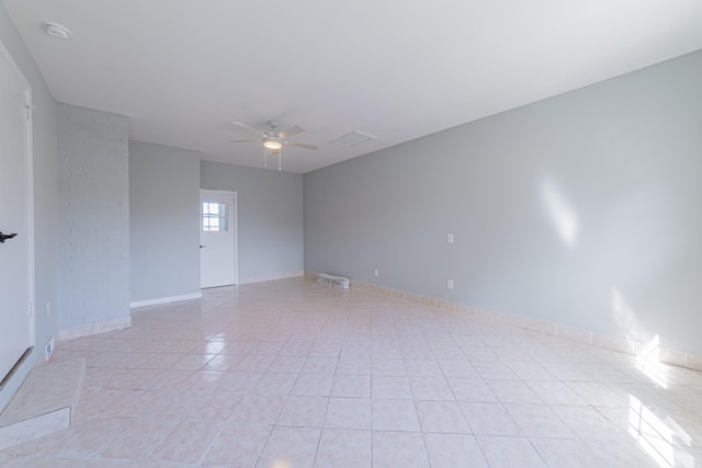 unfurnished room with light tile patterned floors, visible vents, a ceiling fan, and baseboards