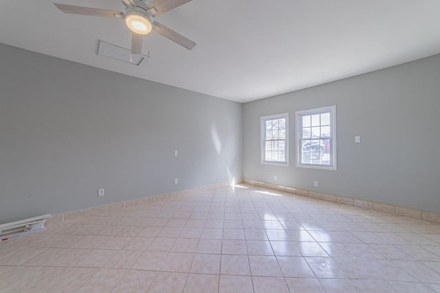 unfurnished room with attic access, ceiling fan, baseboards, and light tile patterned floors