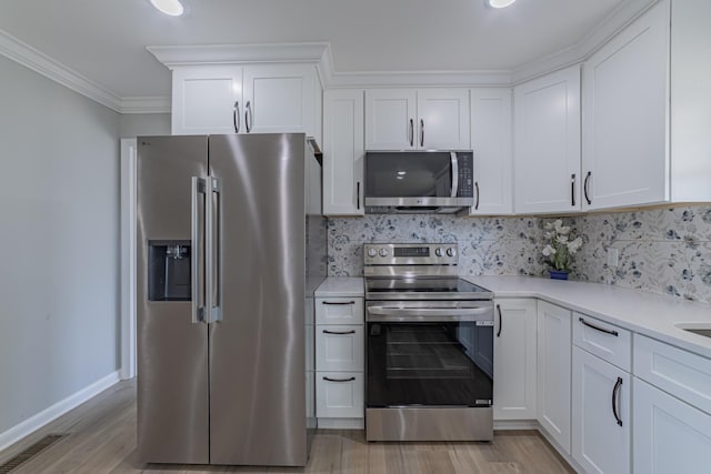 kitchen with light wood-type flooring, tasteful backsplash, stainless steel appliances, and light countertops