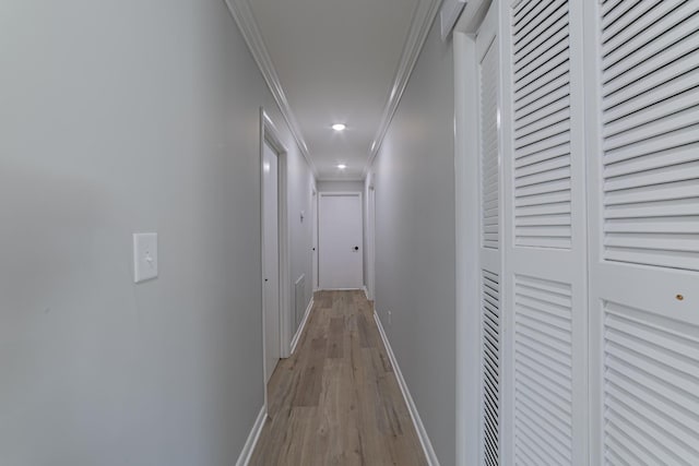 corridor featuring light wood-style floors, baseboards, crown molding, and recessed lighting