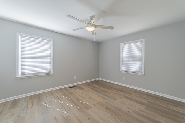 unfurnished room featuring wood finished floors, a ceiling fan, and baseboards