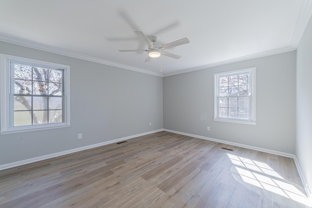 unfurnished room with light wood finished floors, ceiling fan, baseboards, and crown molding