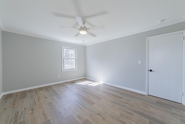 unfurnished room with ornamental molding, light wood-type flooring, a ceiling fan, and baseboards