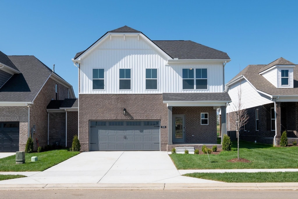 view of front facade with a garage, driveway, a front lawn, and brick siding