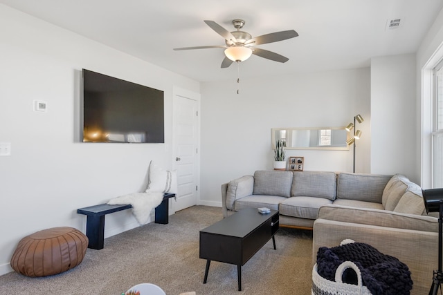 living room featuring light carpet, ceiling fan, visible vents, and baseboards