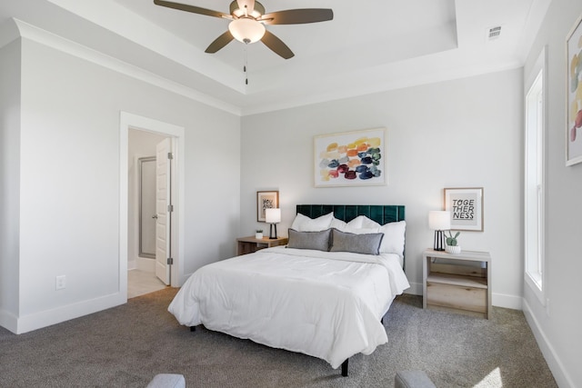 bedroom featuring a tray ceiling, visible vents, and light colored carpet