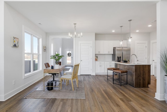 dining space featuring dark wood-type flooring, recessed lighting, baseboards, and an inviting chandelier