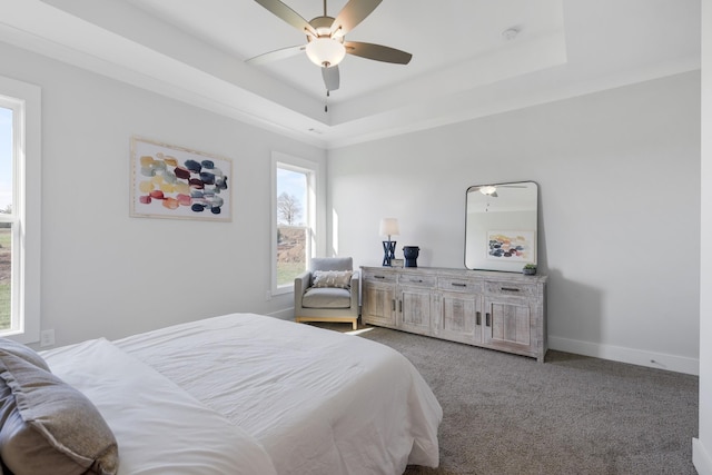 bedroom featuring ceiling fan, baseboards, a raised ceiling, and carpet flooring