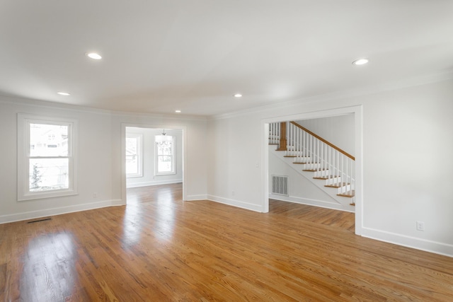 interior space with light wood-style flooring, visible vents, and crown molding