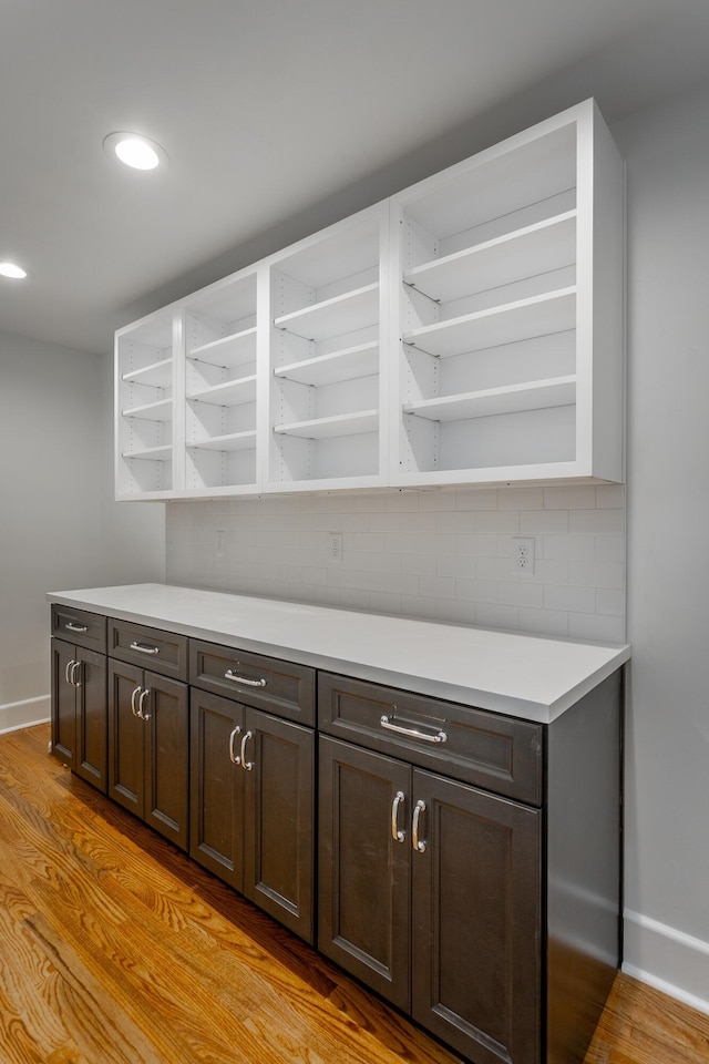 bar with baseboards, light wood-style floors, recessed lighting, and decorative backsplash