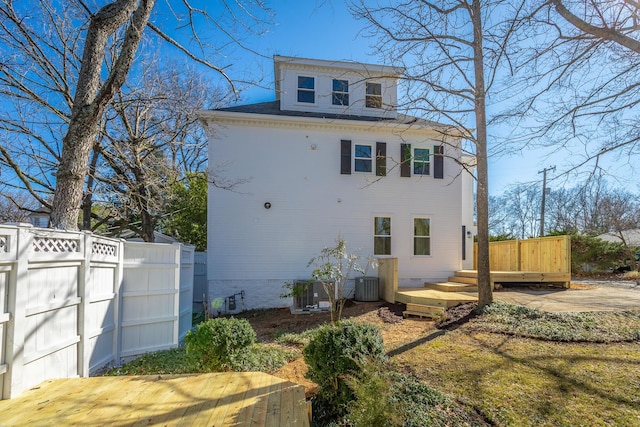 view of property exterior with a deck, cooling unit, and fence