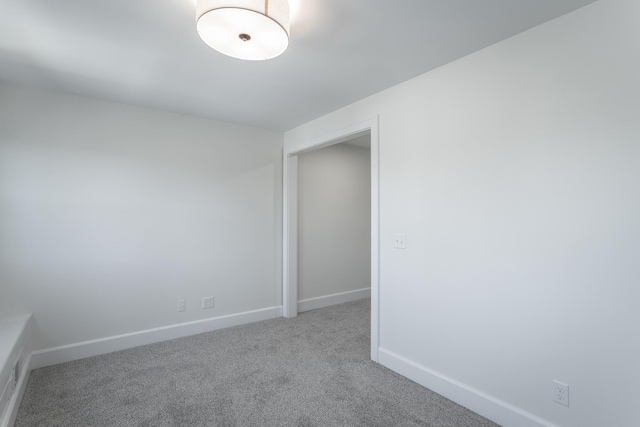 carpeted empty room featuring baseboards