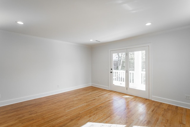 unfurnished room featuring light wood finished floors, baseboards, and crown molding