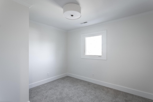 empty room featuring carpet flooring, visible vents, crown molding, and baseboards