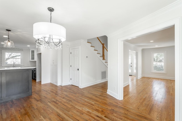 unfurnished dining area with stairs, ornamental molding, dark wood-style floors, and visible vents