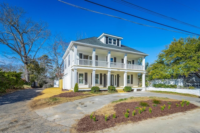 view of front of property featuring covered porch, driveway, and roof with shingles