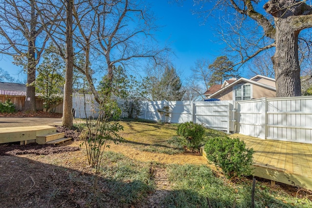 view of yard with a fenced backyard and a wooden deck