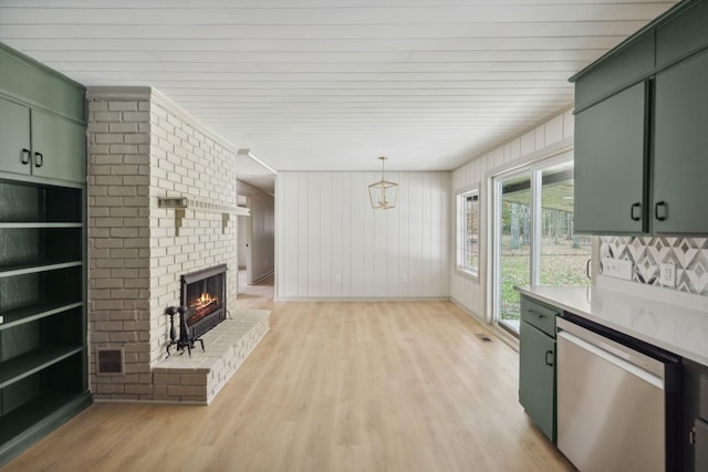 kitchen featuring dishwasher, green cabinets, light countertops, a brick fireplace, and pendant lighting