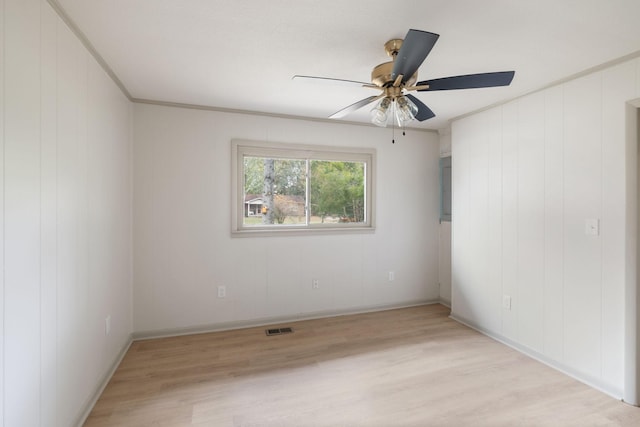 spare room with baseboards, visible vents, crown molding, and light wood finished floors