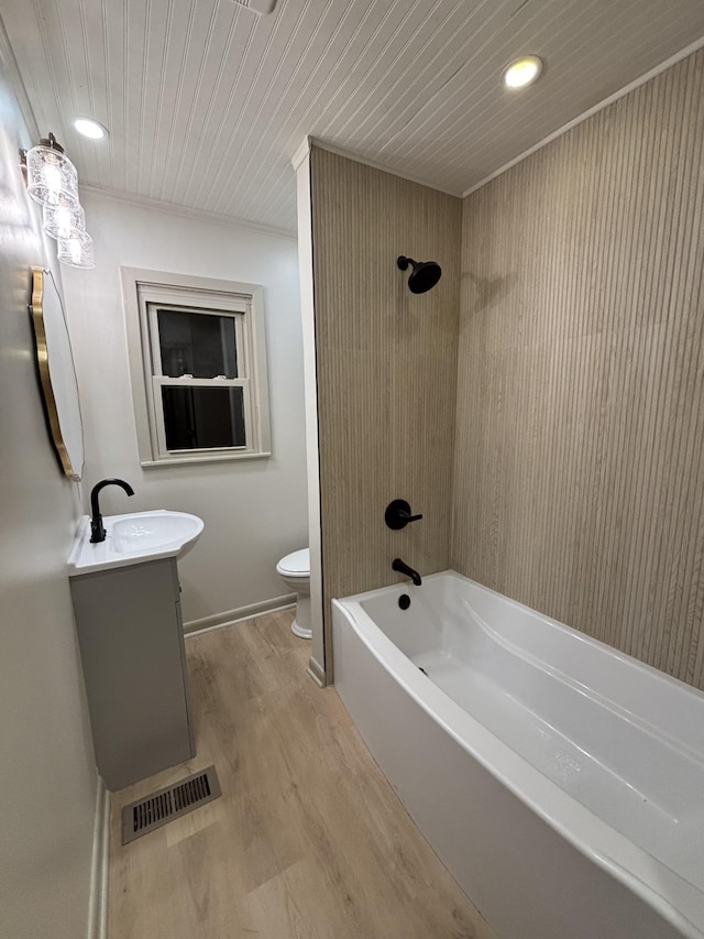 bathroom featuring shower / tub combination, toilet, wood finished floors, vanity, and visible vents