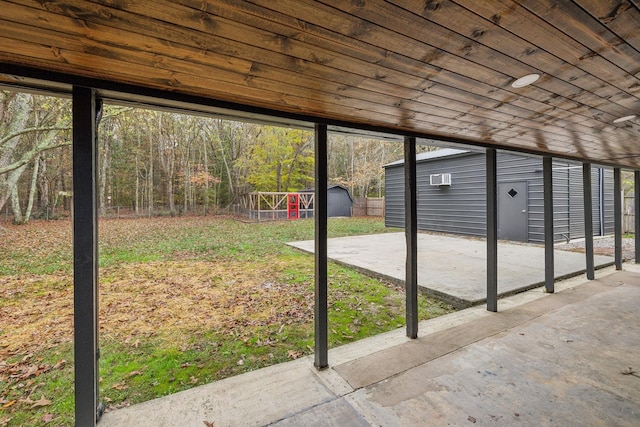 view of patio featuring an outbuilding, fence, and a shed