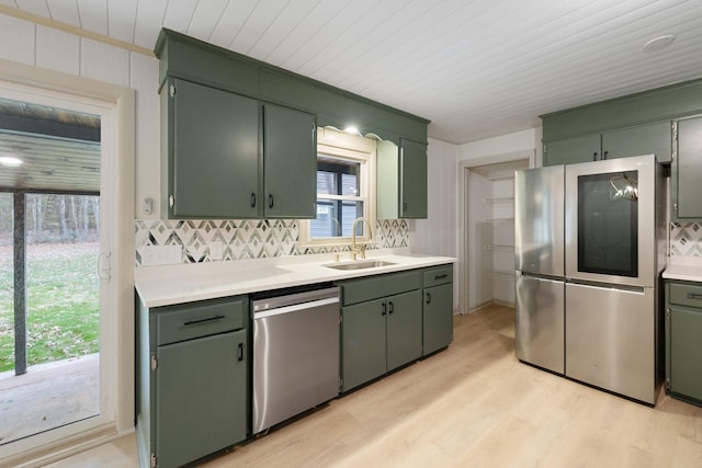 kitchen with appliances with stainless steel finishes, light countertops, and green cabinets