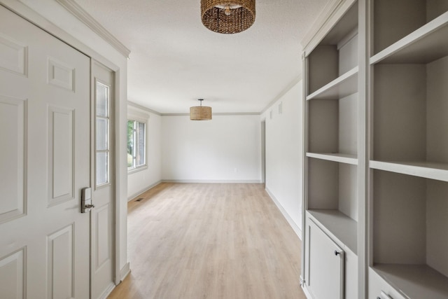 hall featuring light wood finished floors, visible vents, baseboards, and a textured ceiling