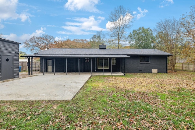 back of house featuring an attached carport, fence, a yard, crawl space, and a patio area