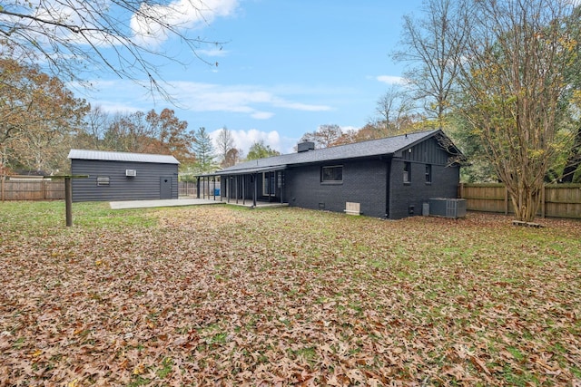 rear view of house featuring central AC, crawl space, a chimney, and a fenced backyard