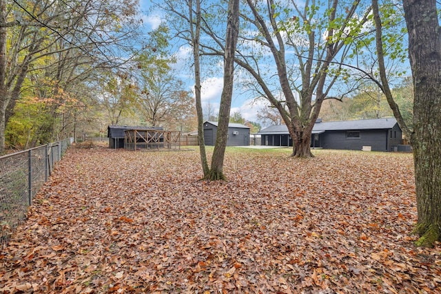 view of yard featuring fence and an outbuilding