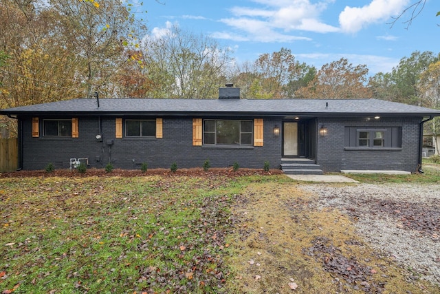 view of front of home featuring a chimney and brick siding